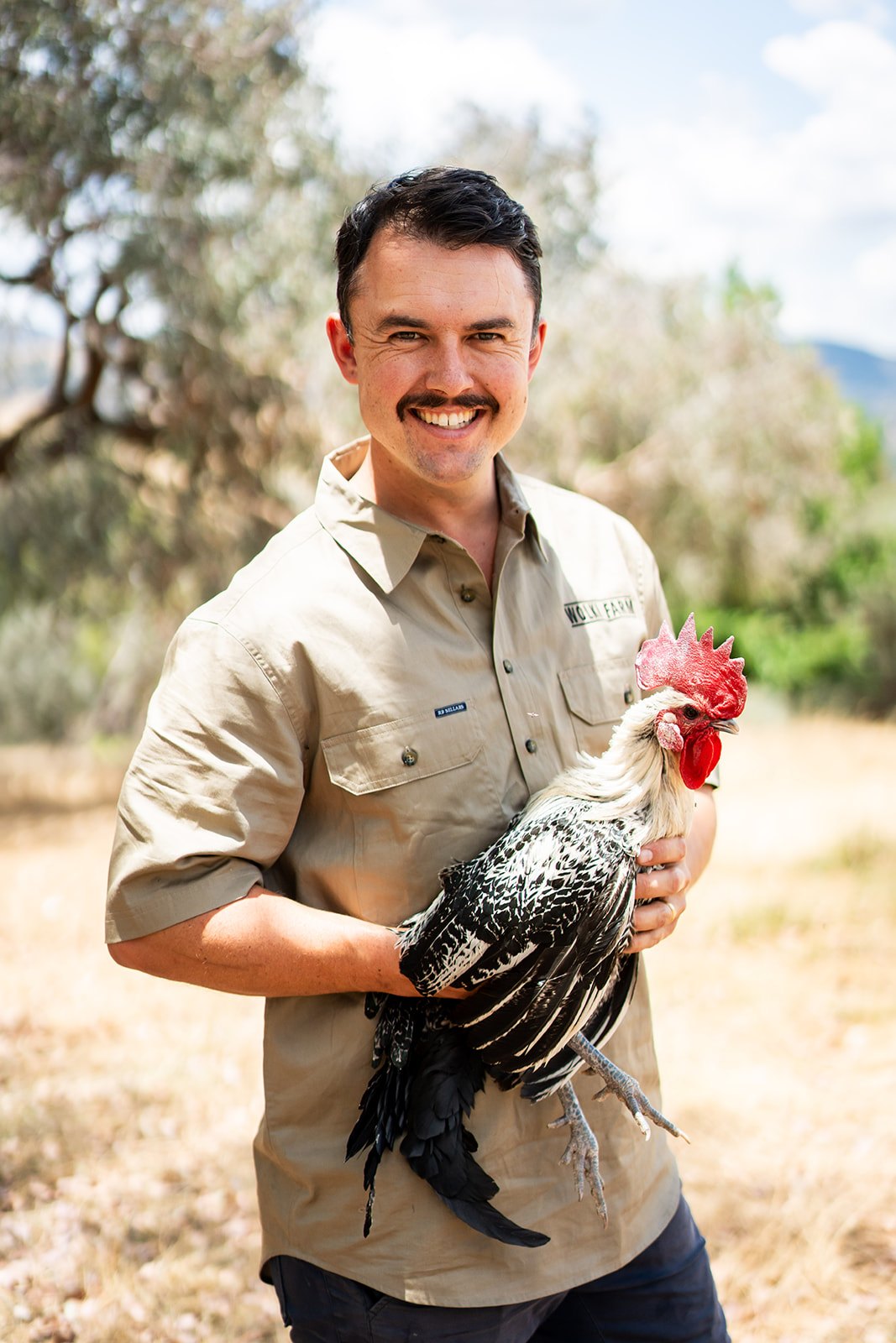 Jake Wolki holding one of the farm's heritage chickens on pasture