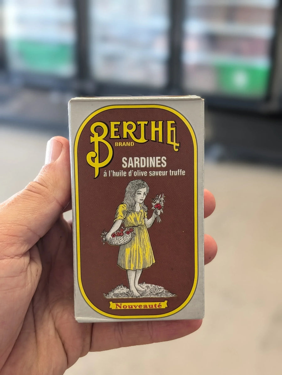 Hand holding a vintage Bertha brand sardines packaging box. — view 2