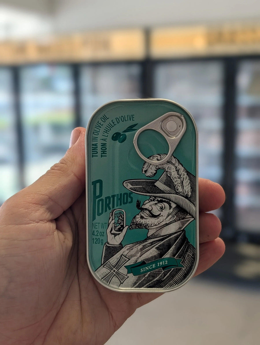 Hand holding a can with a decorative label featuring a graphic design. — view 2