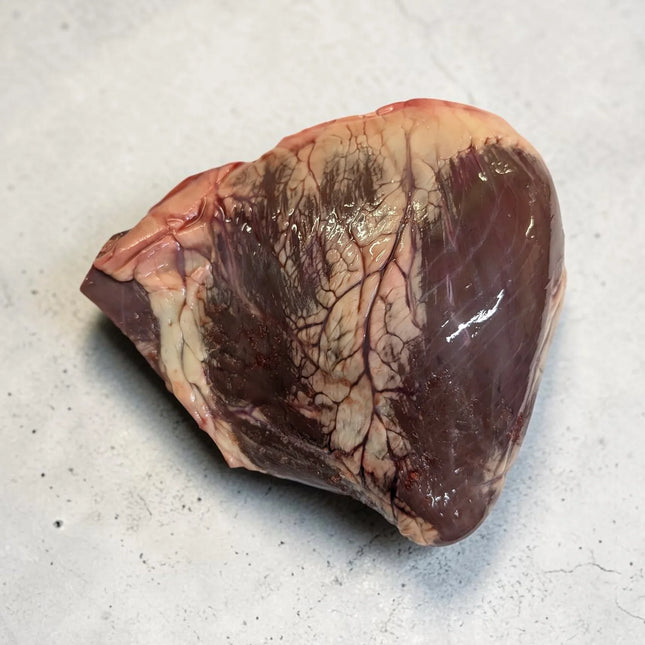 Raw beef heart on a light gray surface