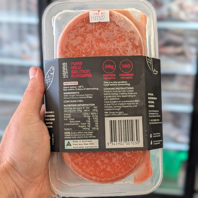 Hand holding a package of salami with a blurred background