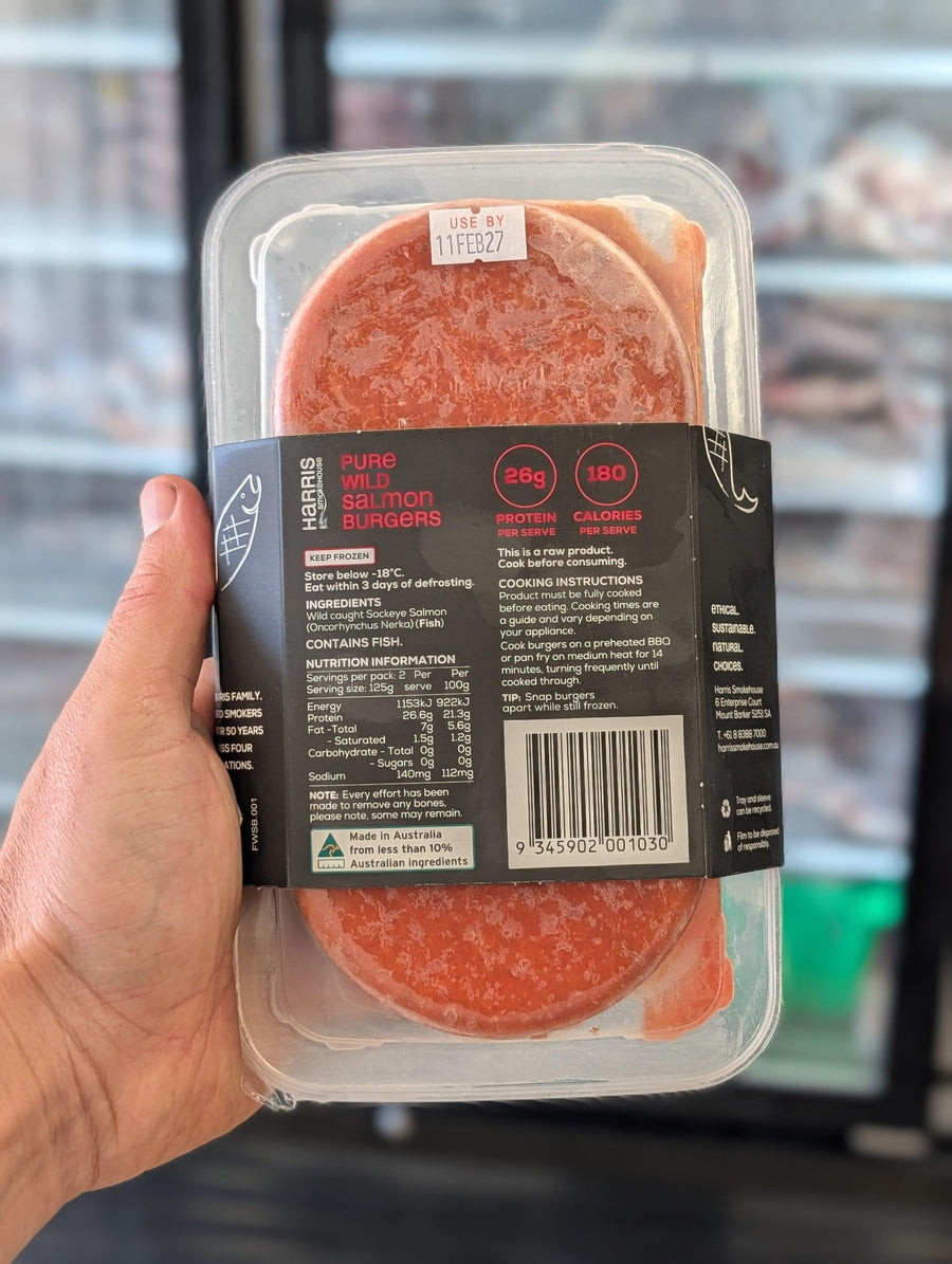 Hand holding a package of salami with a blurred background — view 3